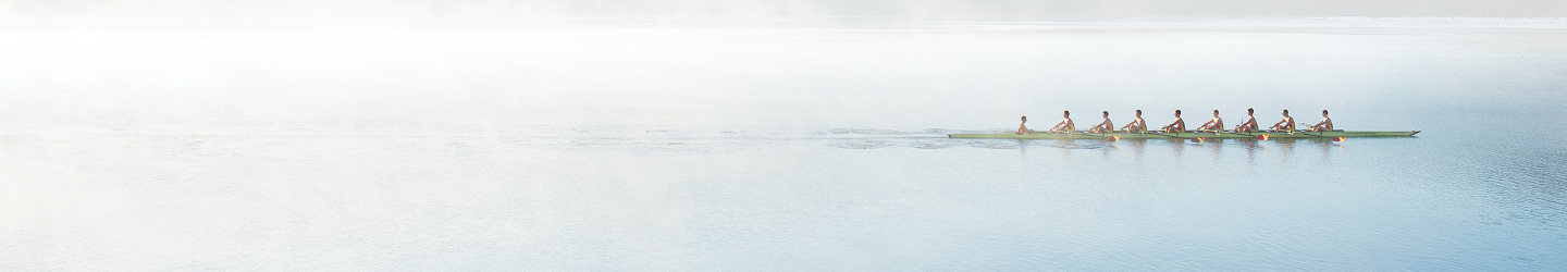Une équipe d'aviron s'entraîne sur un lac.