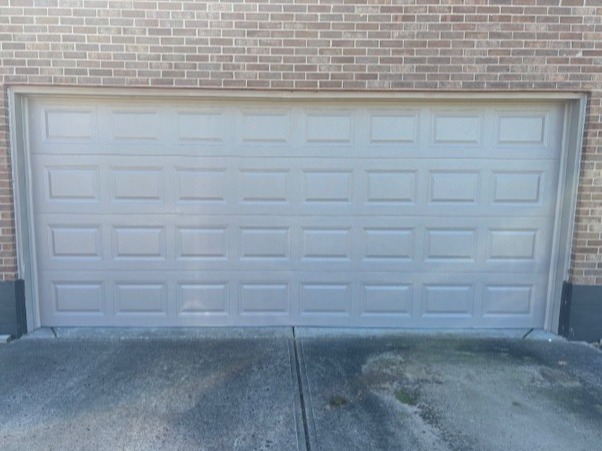 Light gray raised-panel sectional garage door designed for a two-car garage, installed by Highfield Door Sales in Springboro, Ohio. This traditional style enhances curb appeal while providing strength, reliability, and everyday functionality.