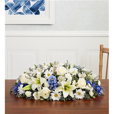Bring an elegant touch to your dining table for guests to enjoy. Our classic centerpiece arrangement is gathered with white and blue flowers, with hints of lavender, creating a charming conversation piece.