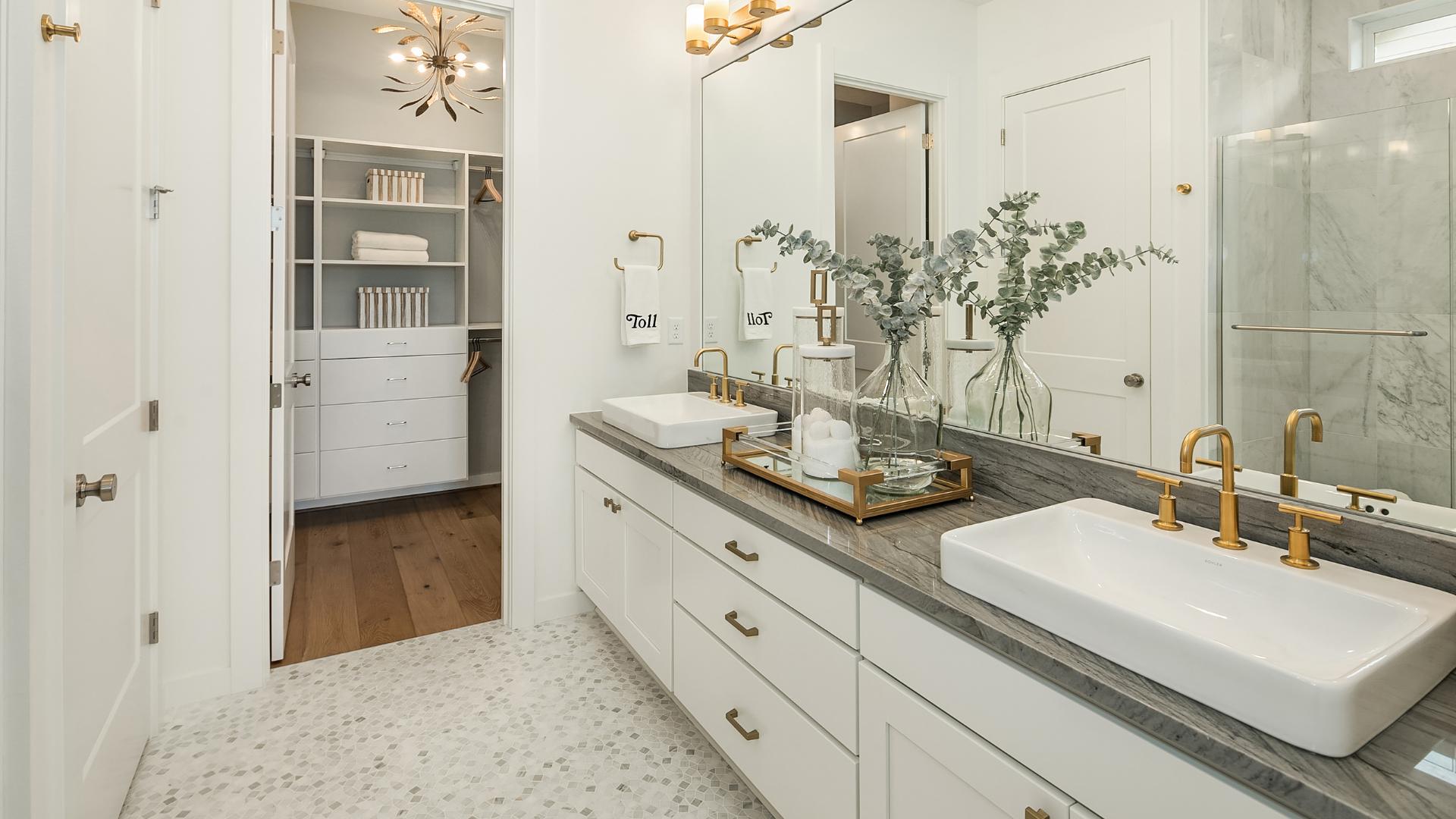 Dual-sink vanity in the Aquila primary bathroom with a walk-in closet