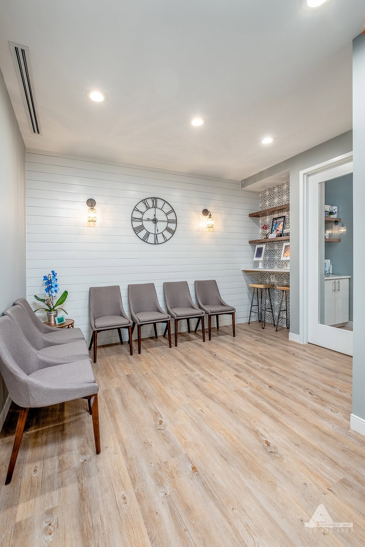 Comfortable patient waiting room at Pure Dental with modern seating, decorative wall clock, and rela 