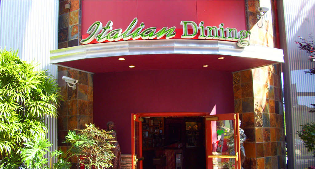 The exterior of Buca di Beppo Universal Citywalk, showing the front doors with an Italian dining sign.