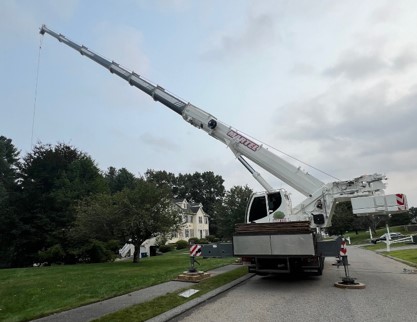 The crew from Martel Crane Service & Tree Removal setup the crane in the street to remove trees from this home in Billerica, MA.