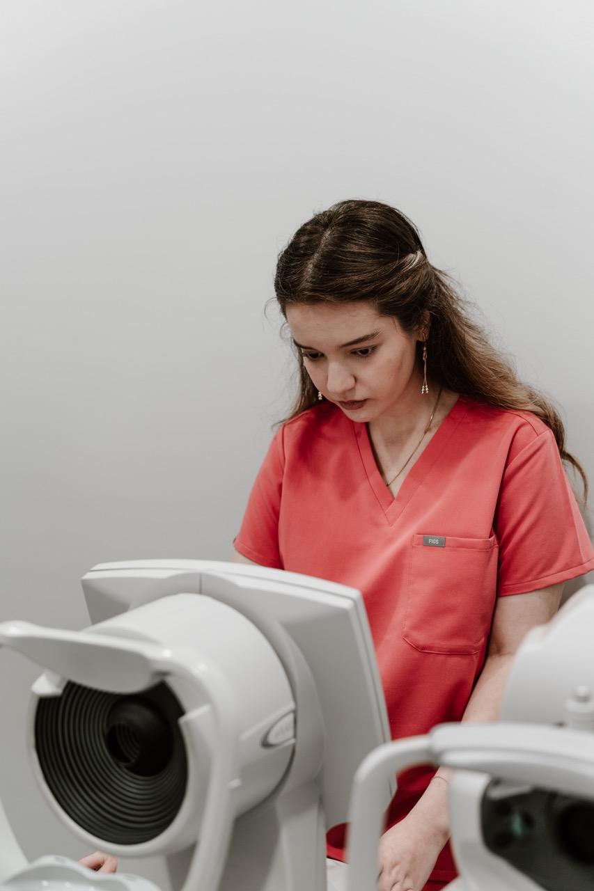 Eye care professional conducting a vision examination using diagnostic equipment at TK Optometry in  