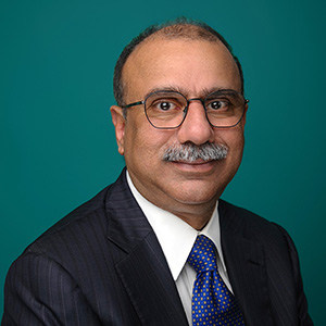 Male interventional cardiologist smiling in professional headshot.