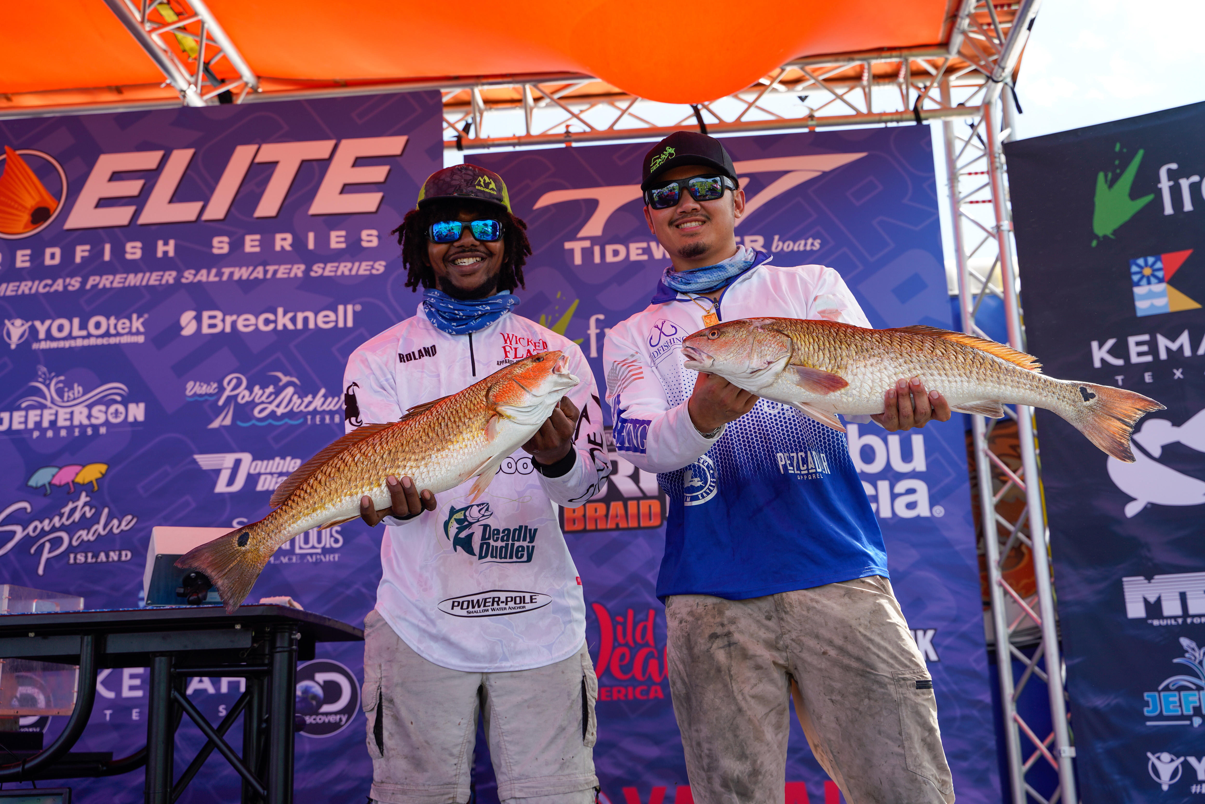 Two tournament anglers hold up their trophy redfish on Pleasure Island in Port Arthur, Texas