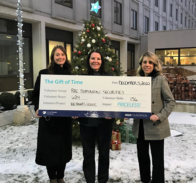 Rhonda Hymers and team posing with a presentation cheque showing the gift of time they've donated.