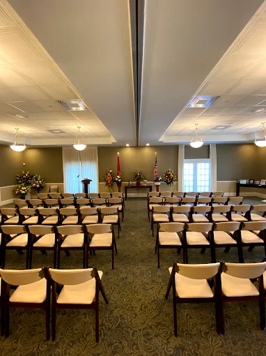 The Brighton chapel arranged theater-style for a funeral service, with rows of upholstered chairs fa 