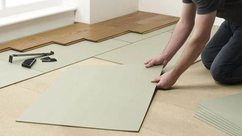 A man laying underlay for laminate flooring