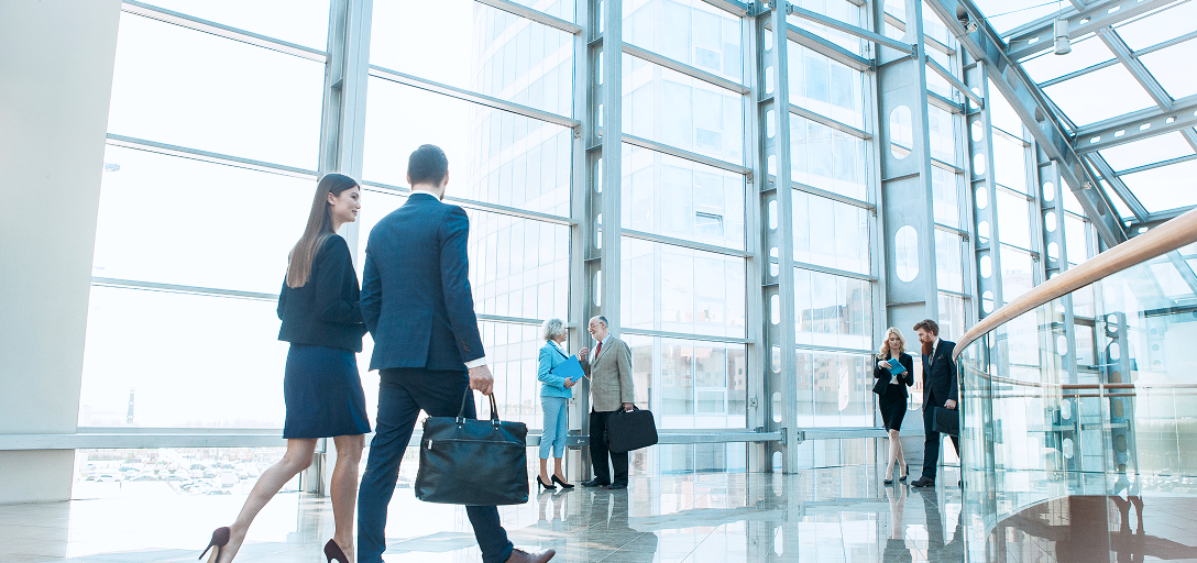 Des personnes marchant dans un hall d’entrée de bureau.
