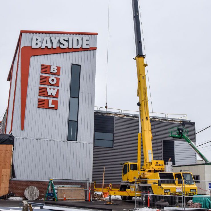 Crane from American Aerial Services operating next to Bayside Bowl in Portland, Maine, providing safe and efficient steel erection and heavy lifting for construction projects.