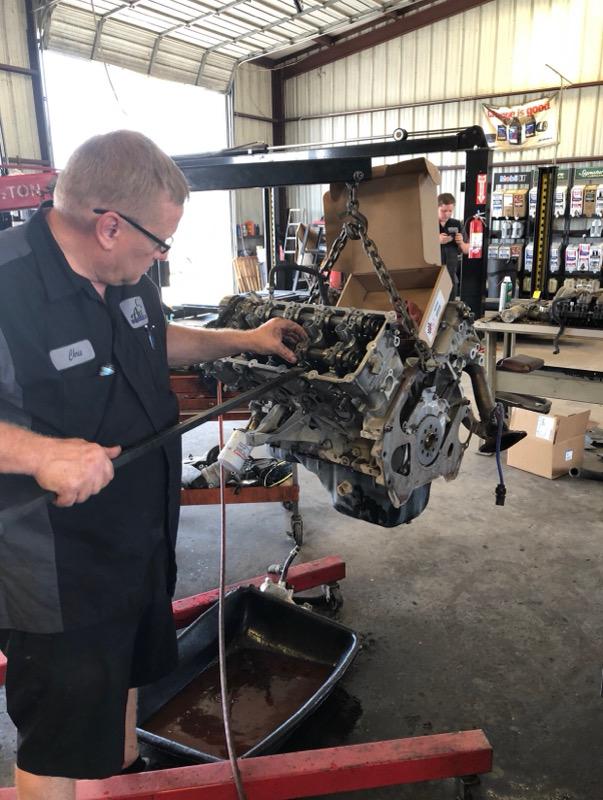 C H Auto Repair mechanics working on a engine.