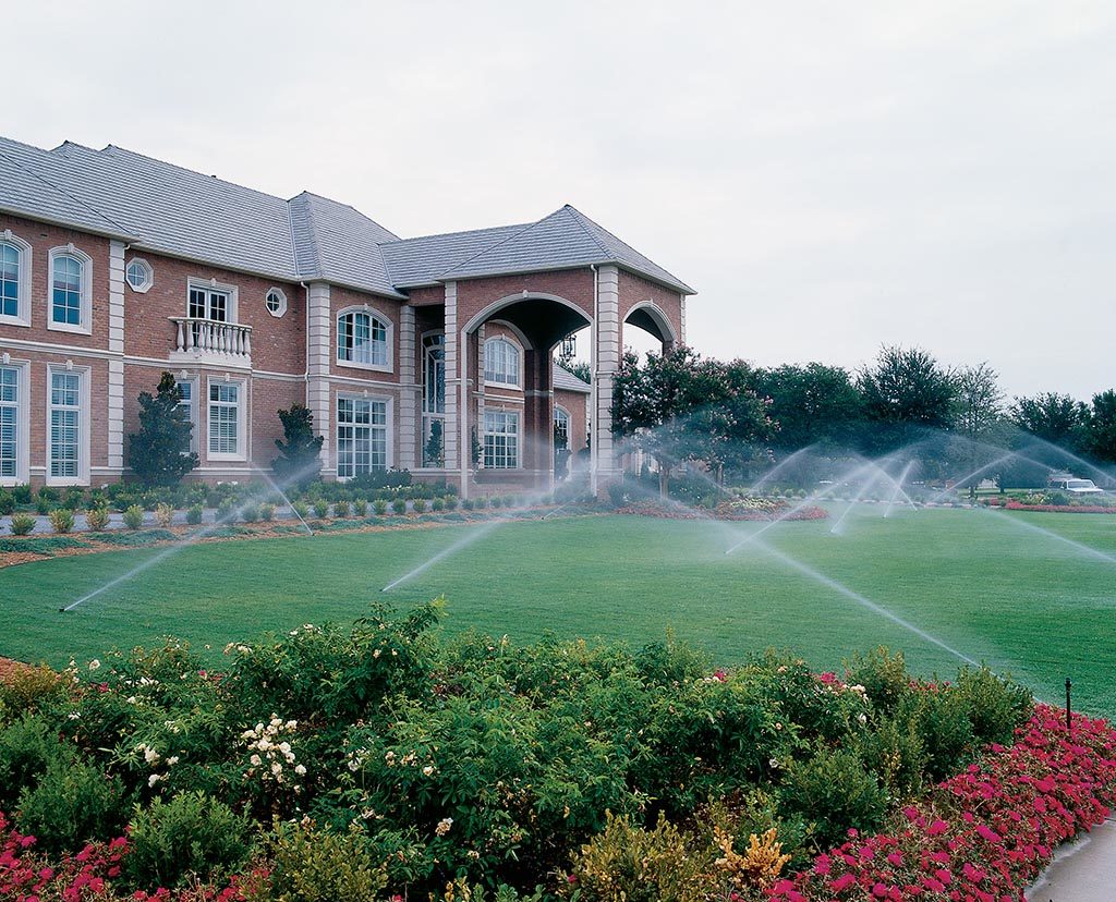 A commercial athletic field irrigation system watering the sports turf inside a large stadium.