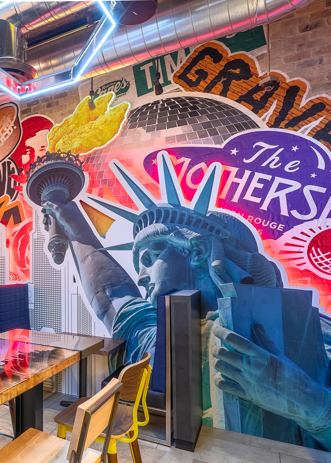 Mural inside Raising Cane's C888 with the Statue of Liberty and a alien ship called "The MotherShip".
