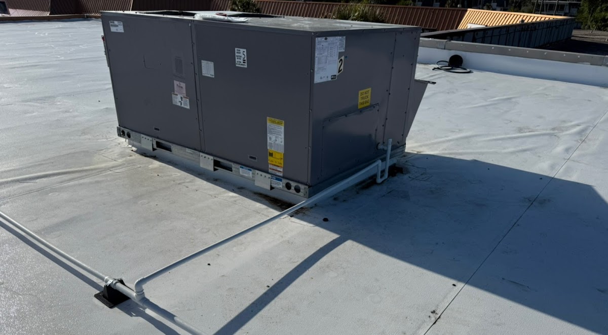 Commercial rooftop HVAC package unit installed on a flat roof with secure connections for reliable heating, cooling, and airflow.