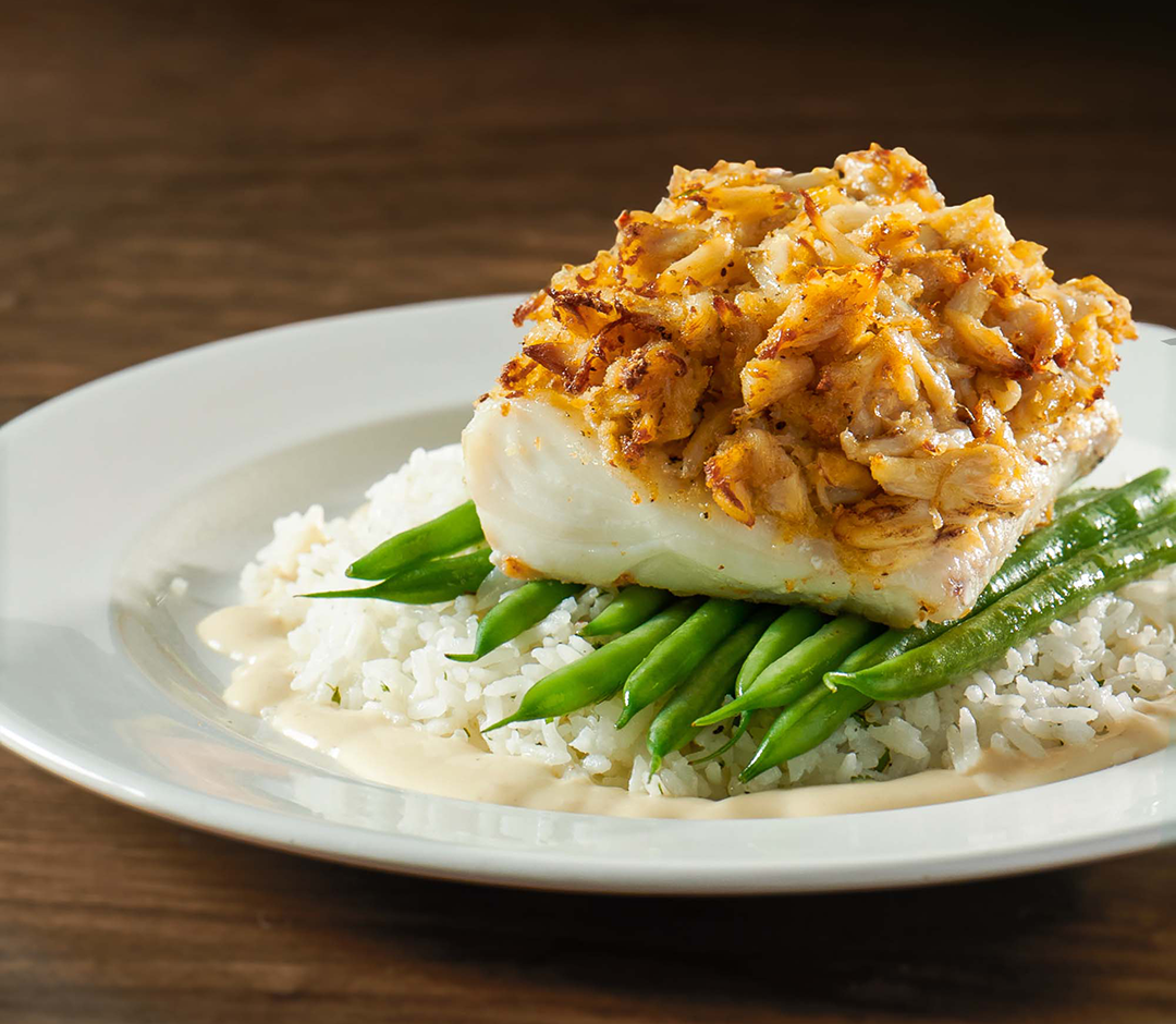 Crab crusted haddock with crab cake, lemon butter sauce, herbed jasmine rice, and seasonal vegetable.