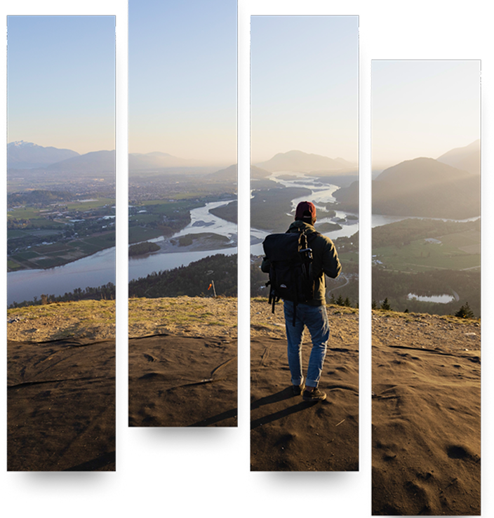 Hiker standing at a lookout point, taking in the view of lakes, greenery, and mountains.