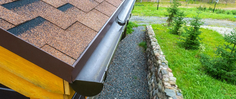 Close-up of a newly installed dark bronze seamless aluminum gutter and drip edge running along the e 