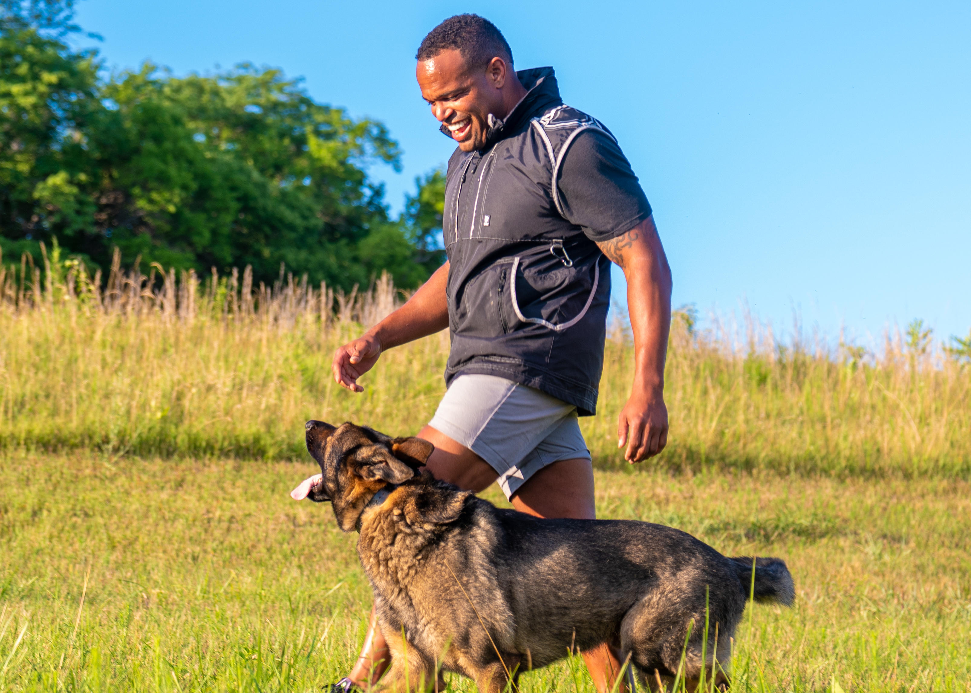 off-leash walking in a field with dog trainer