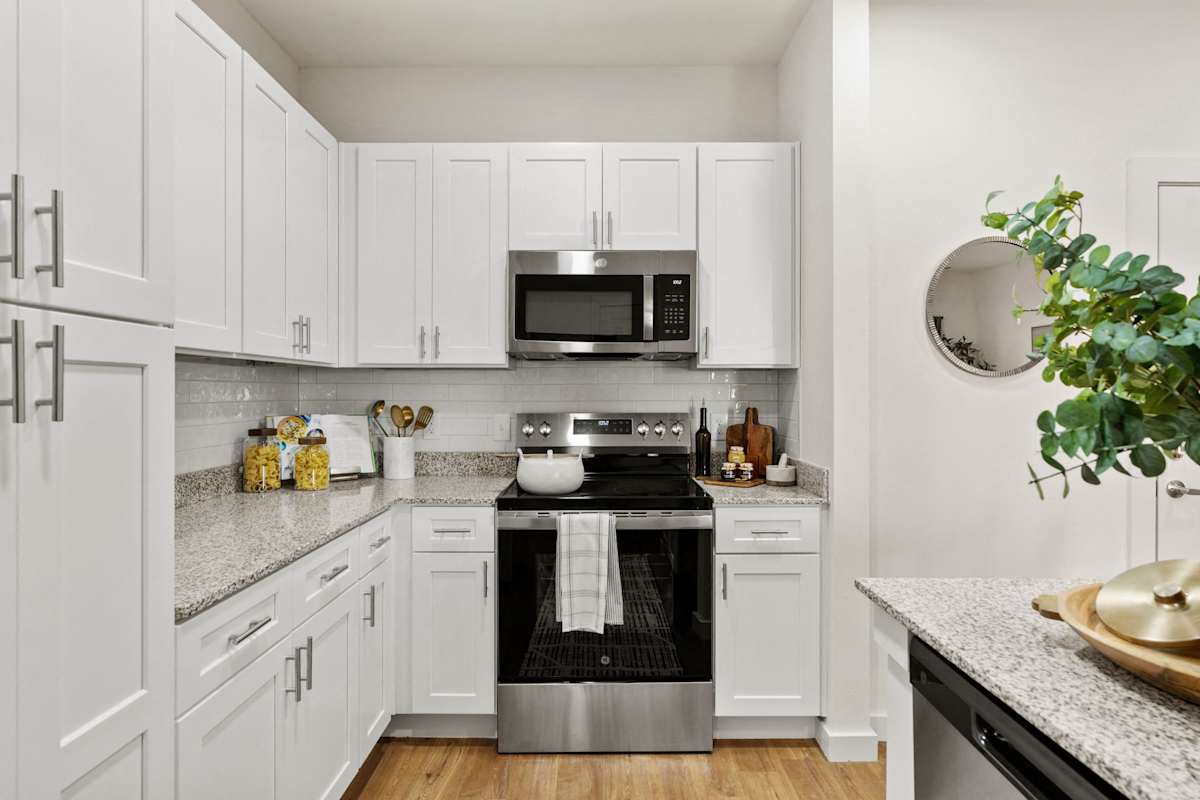 A white kitchen with a microwave above the stove. 