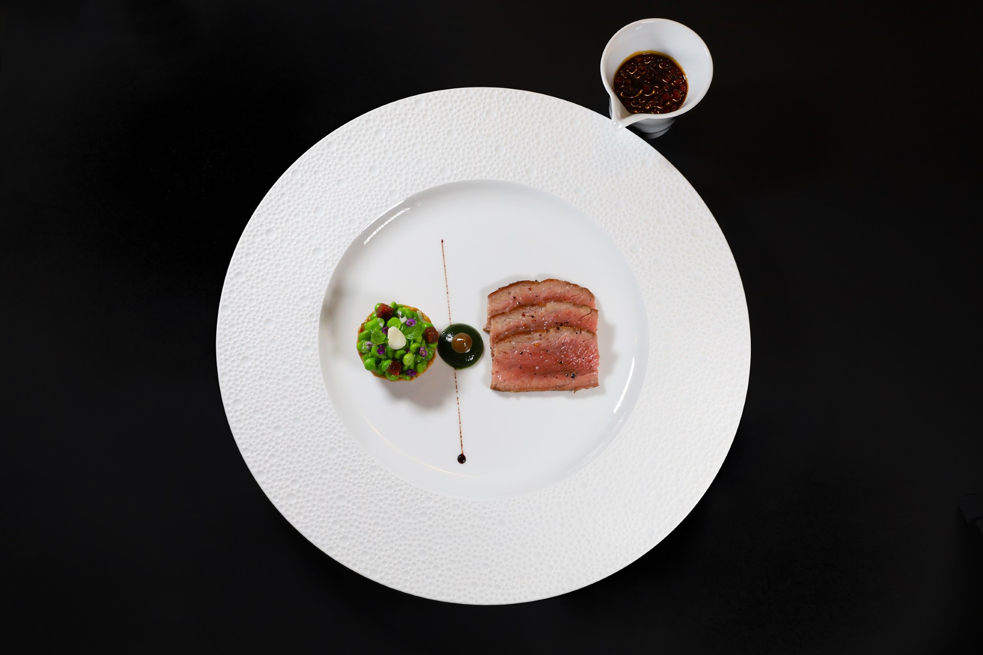 Iberico pork, presa de bellota, with king oyster mushroom and omija berries jus. A main course option on Chef Christophe Bellanca's Discovery Menu.