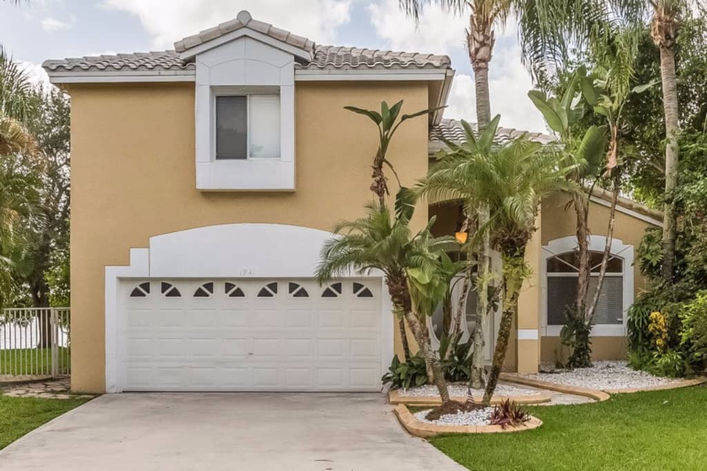 Charming home with a two-car garage and beautiful landscaping at Invitation Homes South Florida.