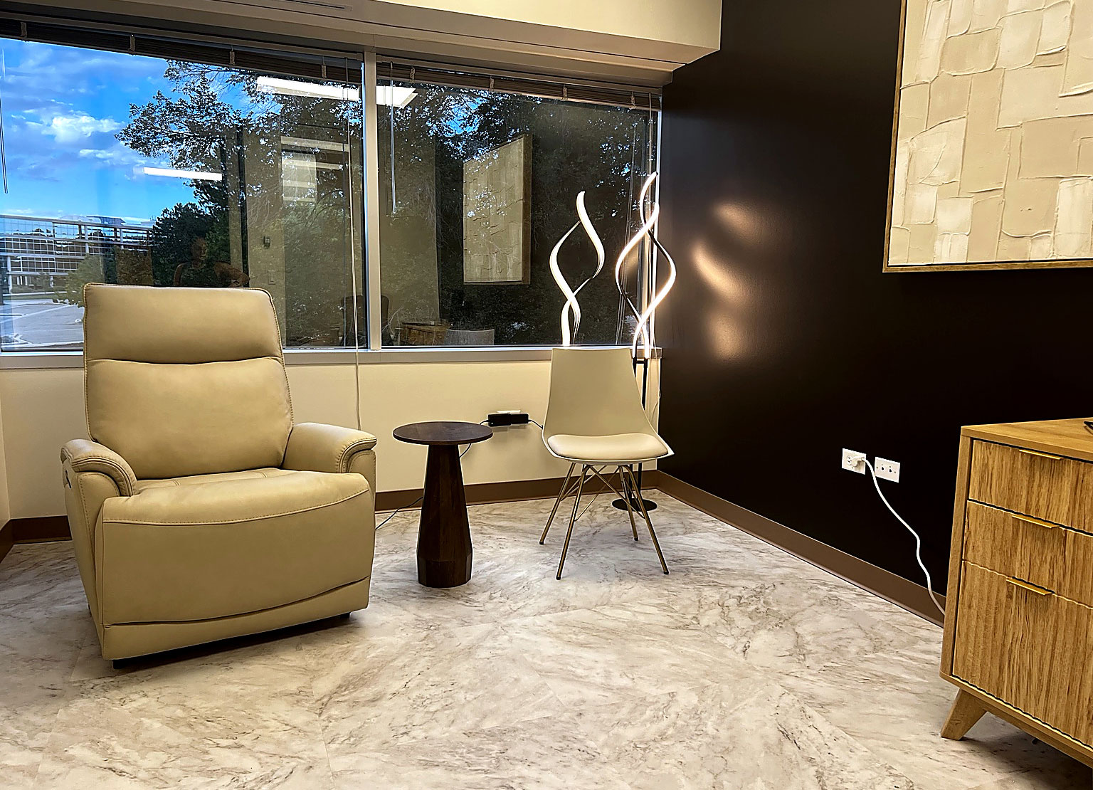 Comfortable lounge area at Transcend Functional Health in Greenwood Village, Colorado, featuring modern seating, natural light, contemporary artwork, and a welcoming atmosphere.