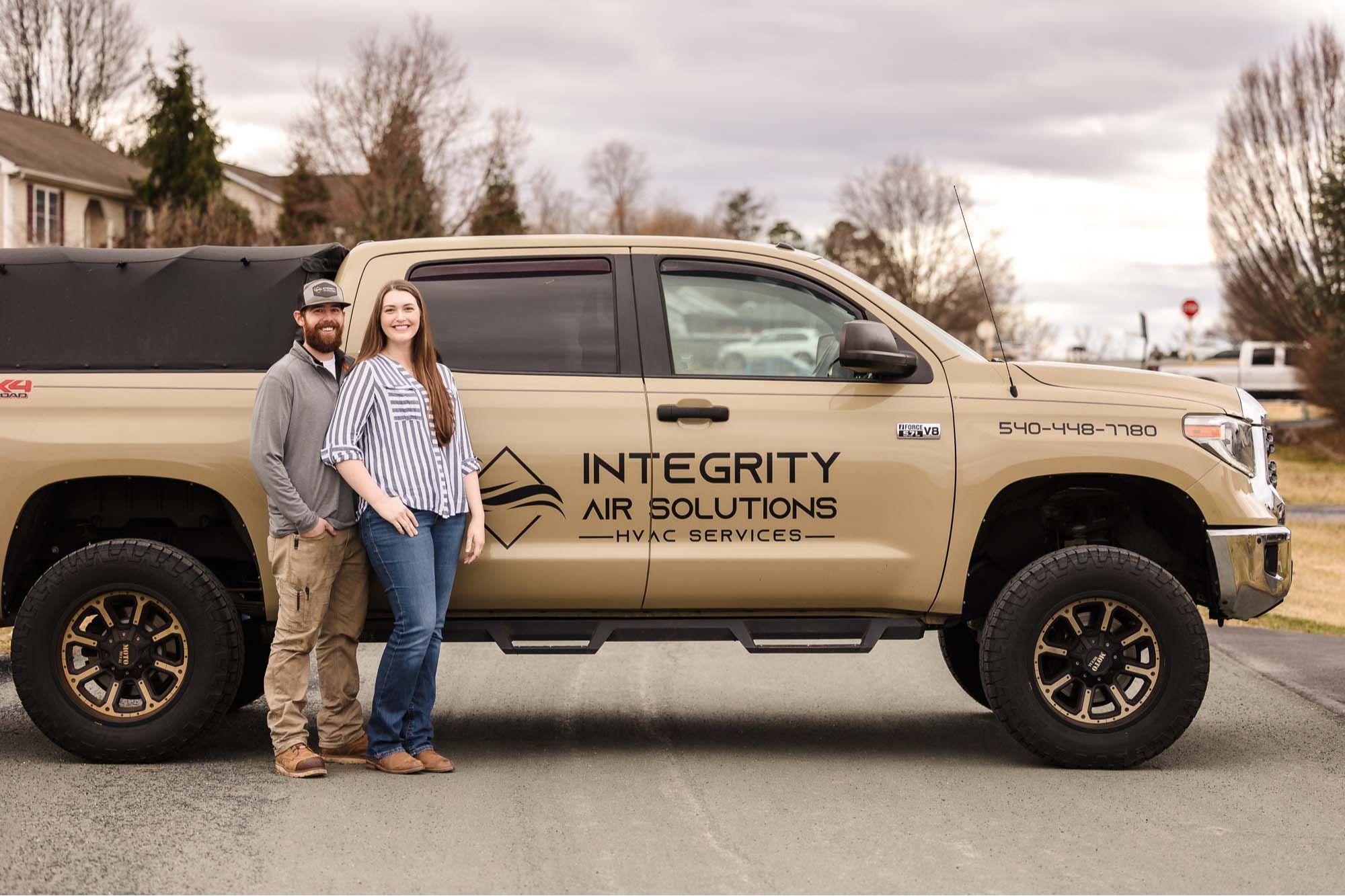 Lucas and Taylor standing next to the Integrity Air Solutions service truck