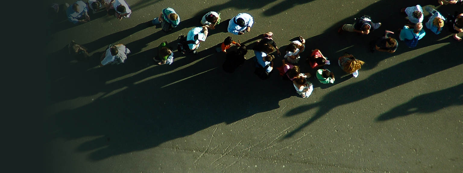 Top-down, aerial view of spectators chatting on a golf course.