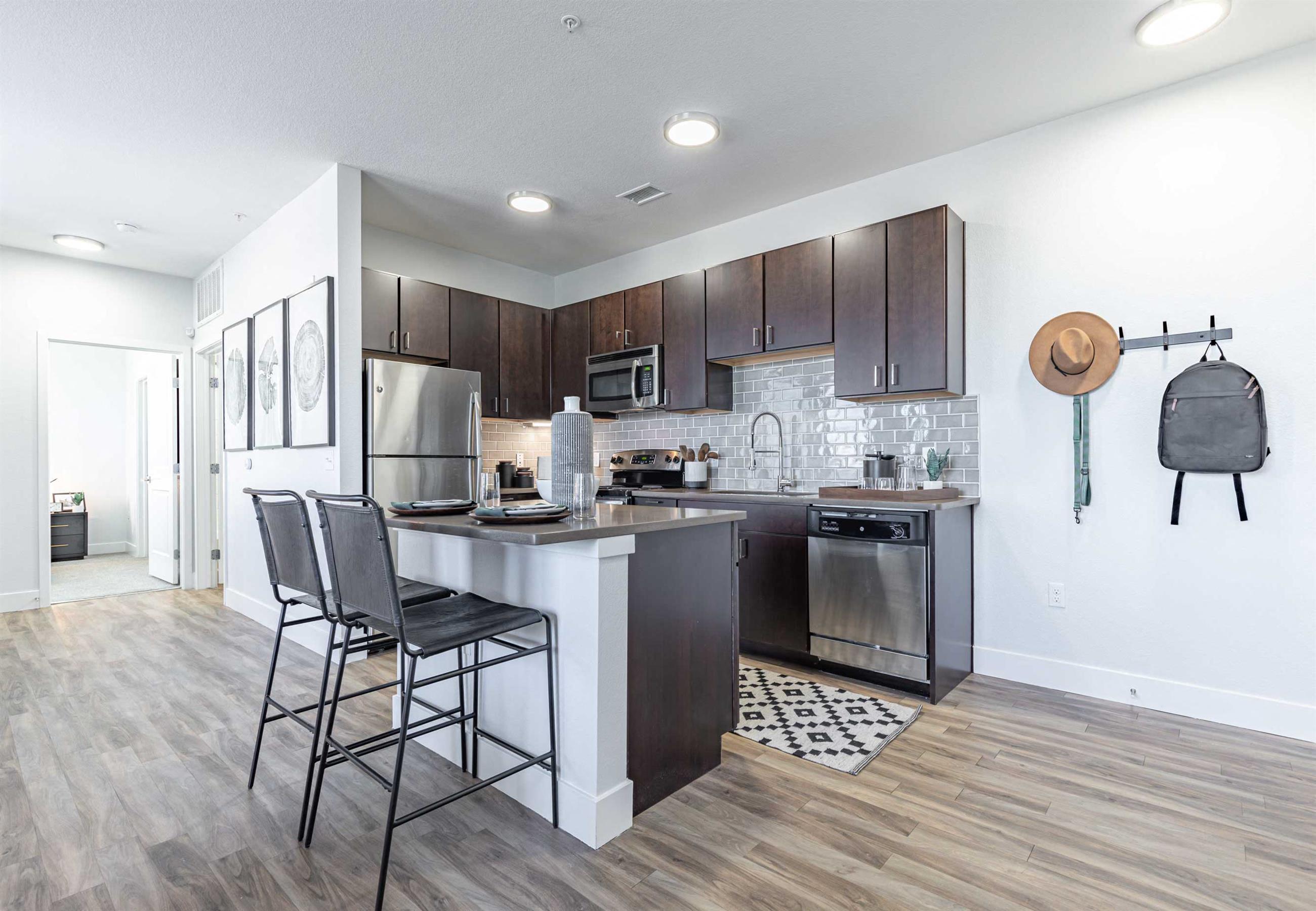 a kitchen with dark wood cabinets and a white island with three stools