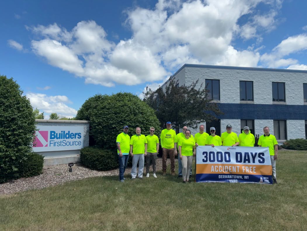 Builders FirstSource team members in Germantown, Wisconsin, standing outside a BFS facility holding a '3000 Days Accident Free' safety milestone banner.