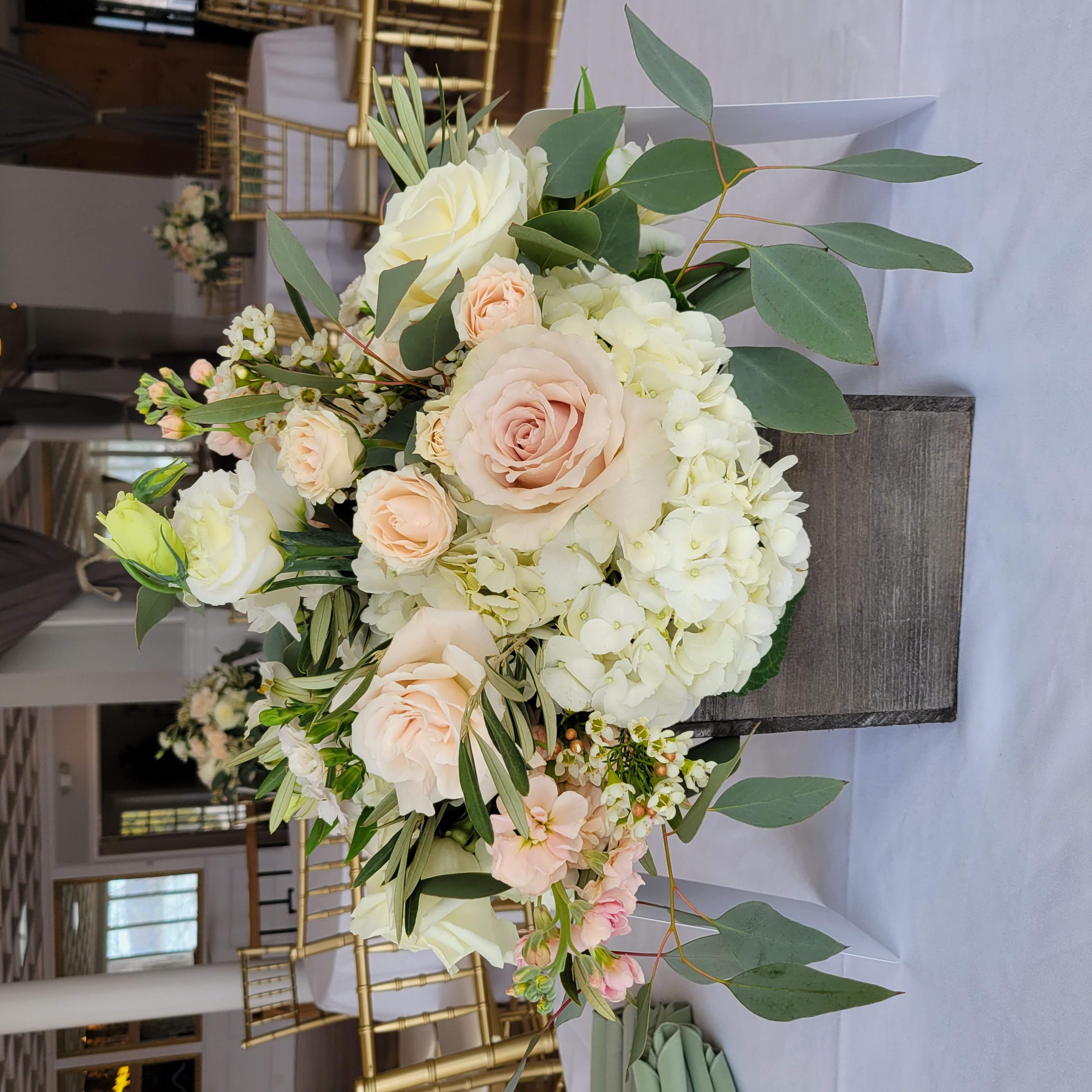 March wedding reception flower centerpiece at Seacliff Manor, Seacliff, NY. Neutral color palette, rustic, and garden style table centerpiece in a wood square container.