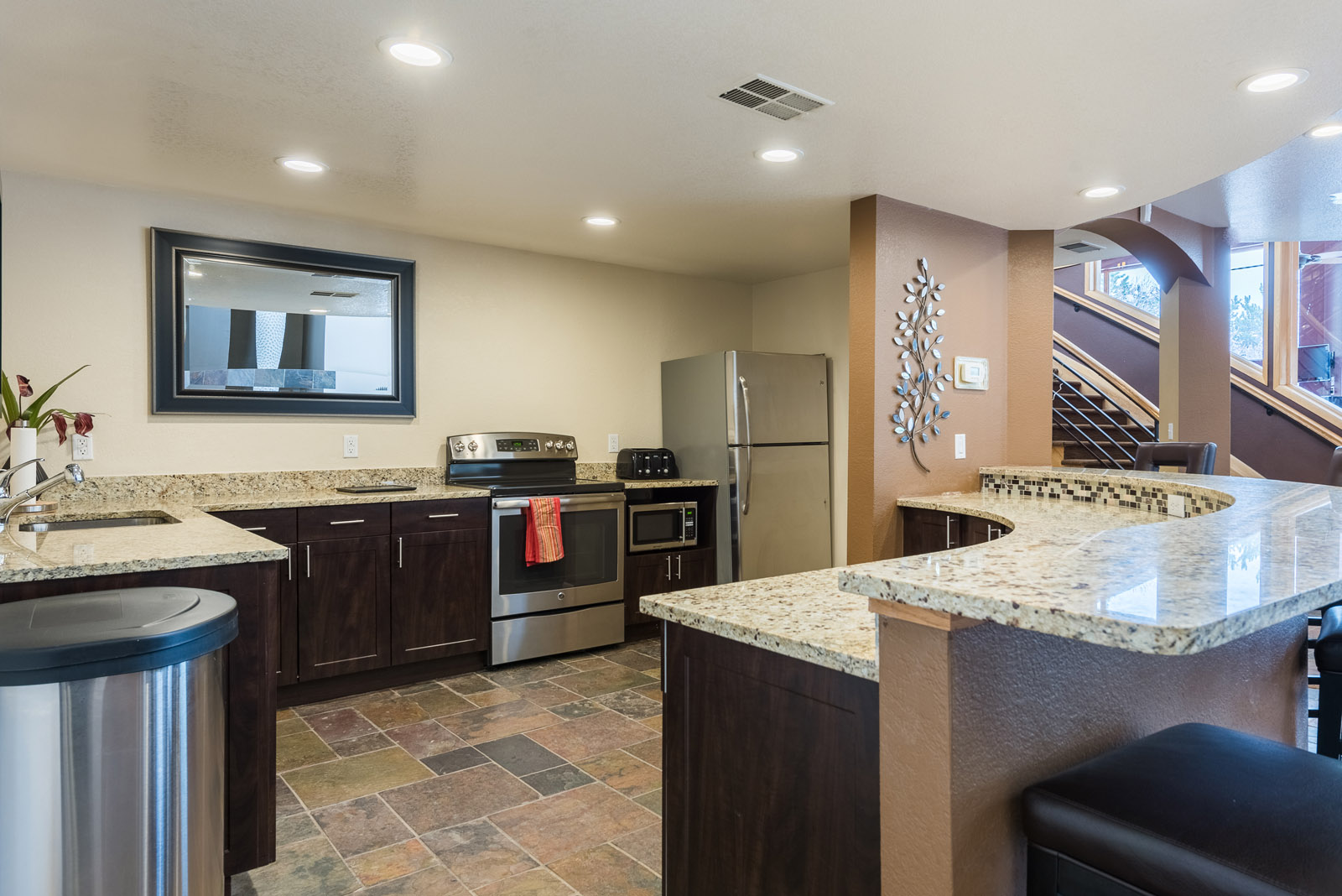 A kitchen with a granite counter top and a fridge.