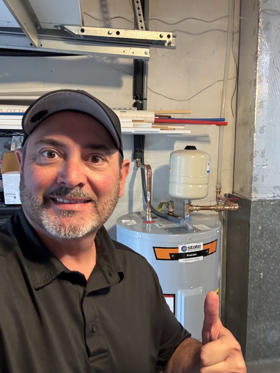 Positively Plumbing technician giving a thumbs-up next to a plumbing system, highlighting professional service and completed plumbing work.