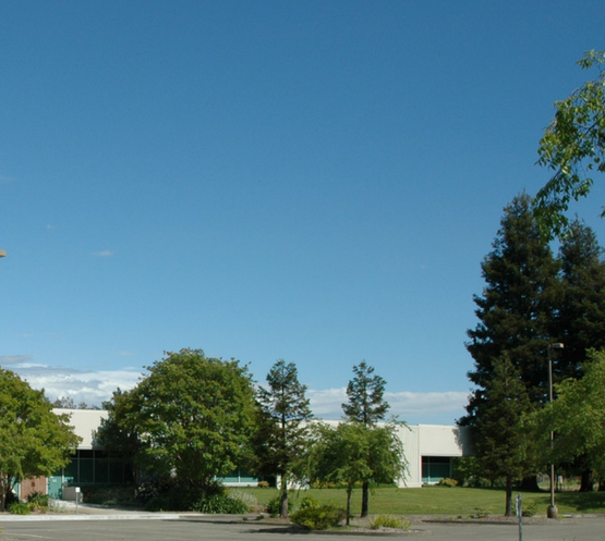 Exterior view of Deposition Sciences' state-of-the-art 144,000 square-foot manufacturing facility located in Santa Rosa, California. The Lockheed Martin-owned facility houses Class 100 and Class 1000 cleanroom environments for producing space-qualified thermal control materials and precision optical coatings for aerospace, defense, and commercial applications.