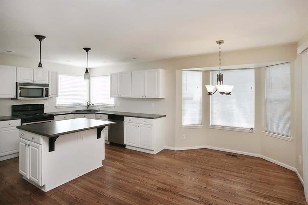 Kitchen with stainless-steel appliances and dining room with bay window at Invitation Homes Denver.