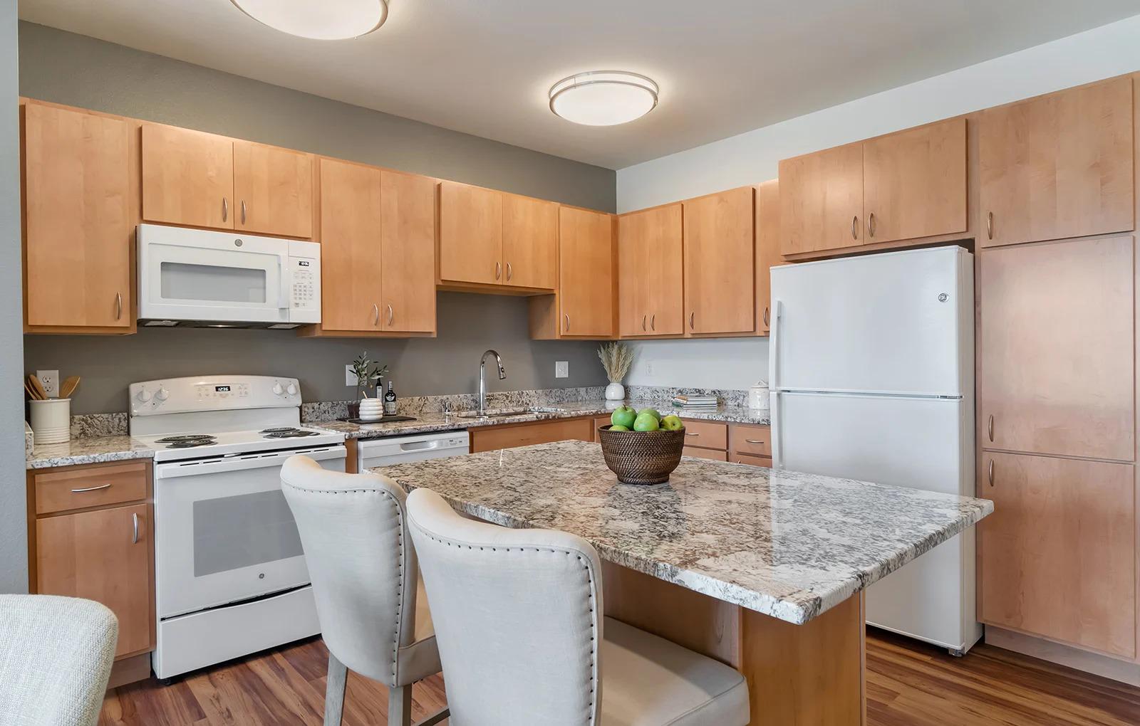 Kitchen with Eat-in Island at Oaks Landing 55+ Apartments