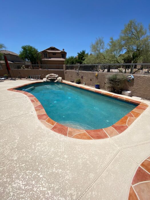 Existing backyard swimming pool before renovation, showing the pool, surrounding deck, coping, and r 