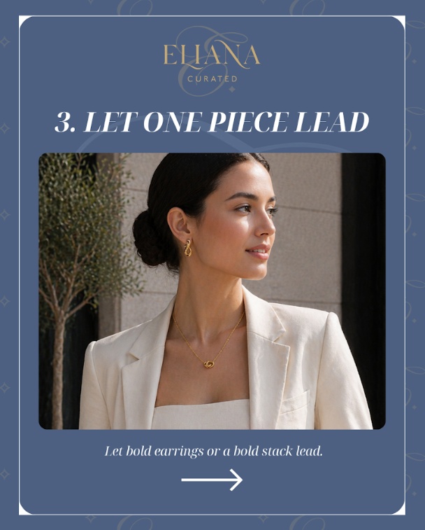Model in a white blazer and matching top wearing bold gold earrings and a delicate matching pendant necklace, demonstrating how to let one statement piece lead.