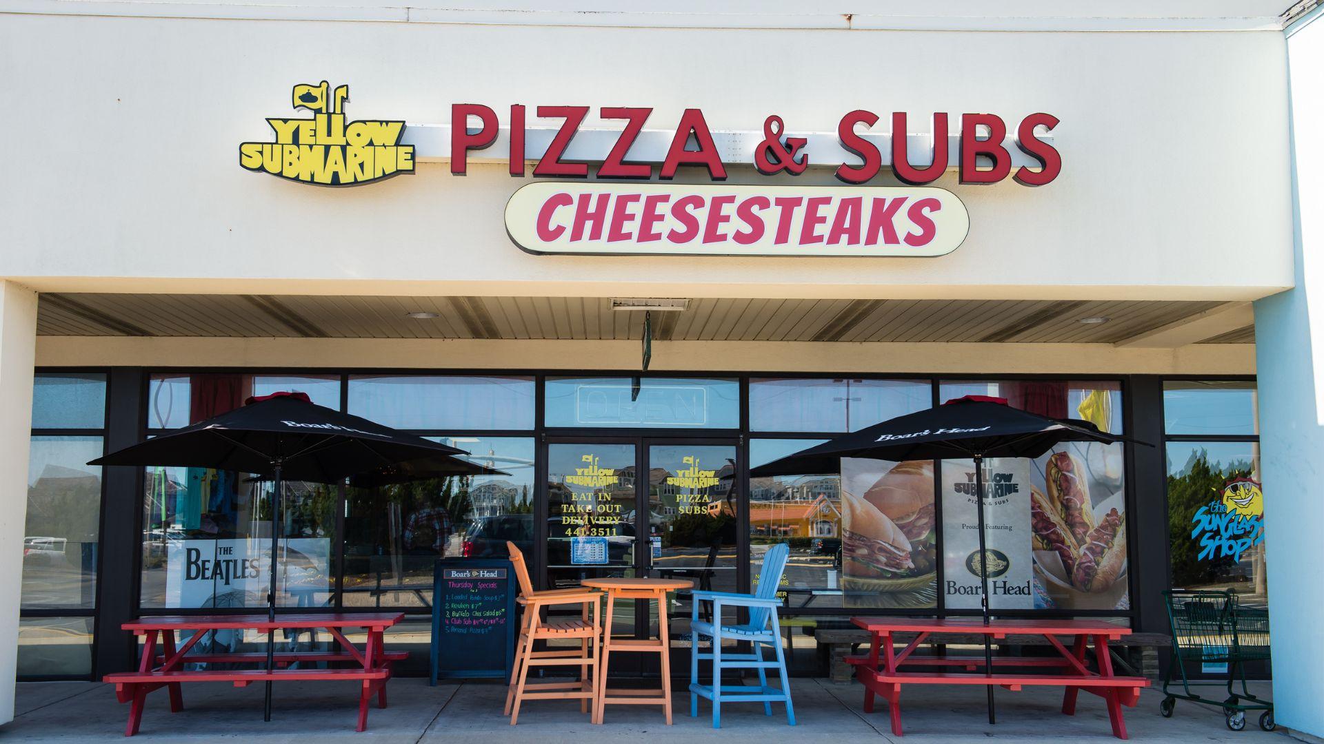 Yellow Submarine Pizza & Subs & Cheesesteaks Storefront with outdoor seating at the Outer Banks Mall in Nags Head, North Carolina.