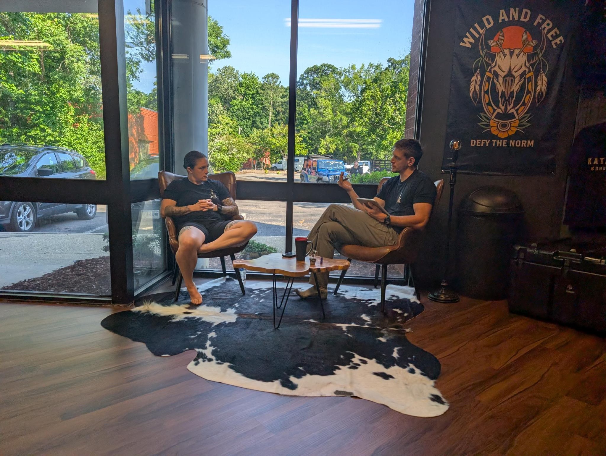 A prospective student meeting with an instructor in the front lounge at Katalyst Kombatives before starting training.