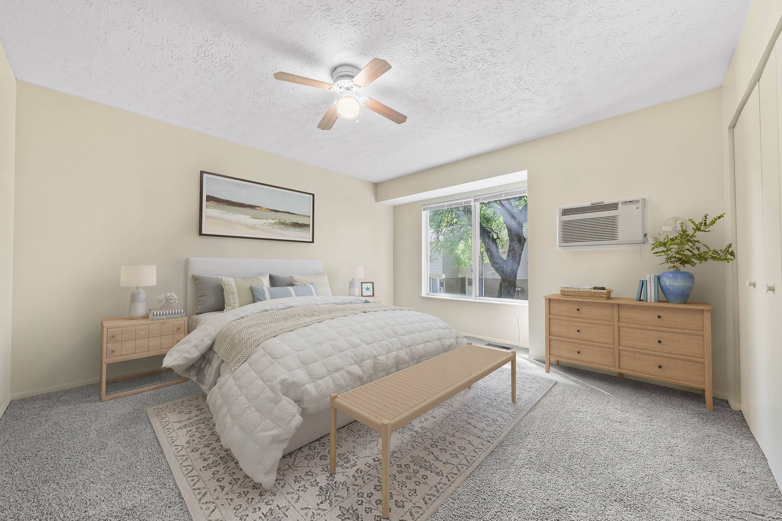 A bedroom with a bed, nightstand, and a ceiling fan