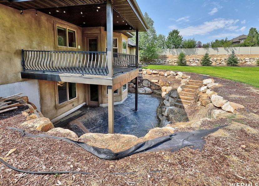 Maximize your home's potential with a custom multi-level outdoor living space from DeckPro LLC. This project features a spacious upper-level deck with a unique curved railing, perfectly complementing the home's architecture. Below, a walk-out basement opens onto an expansive concrete patio, creating two distinct areas for relaxing and entertaining.