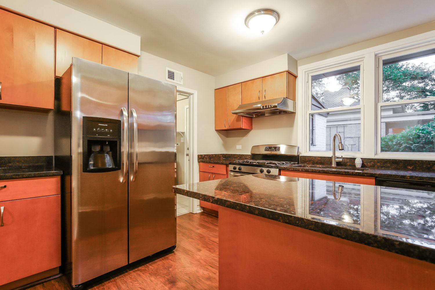 Modern kitchen with granite counters and stainless steel appliances at Invitation Homes Chicago.