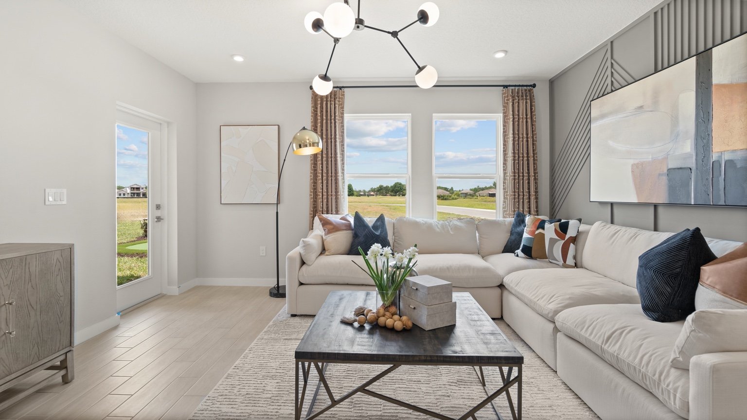 The Jupiter Model Home Open Concept Living Area at Grasslands West by DRB Homes