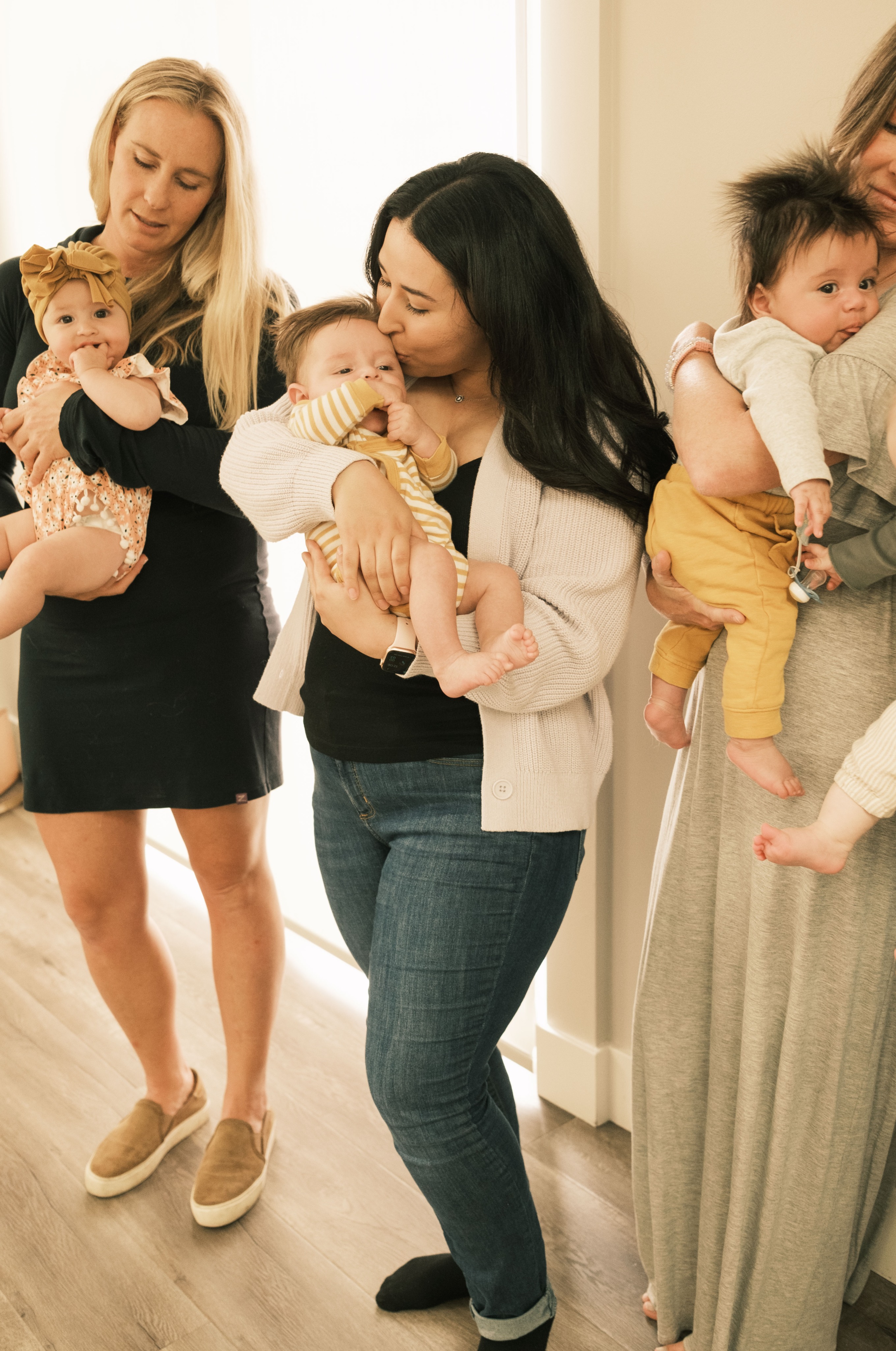 A new mom holds her baby close and kisses their forehead