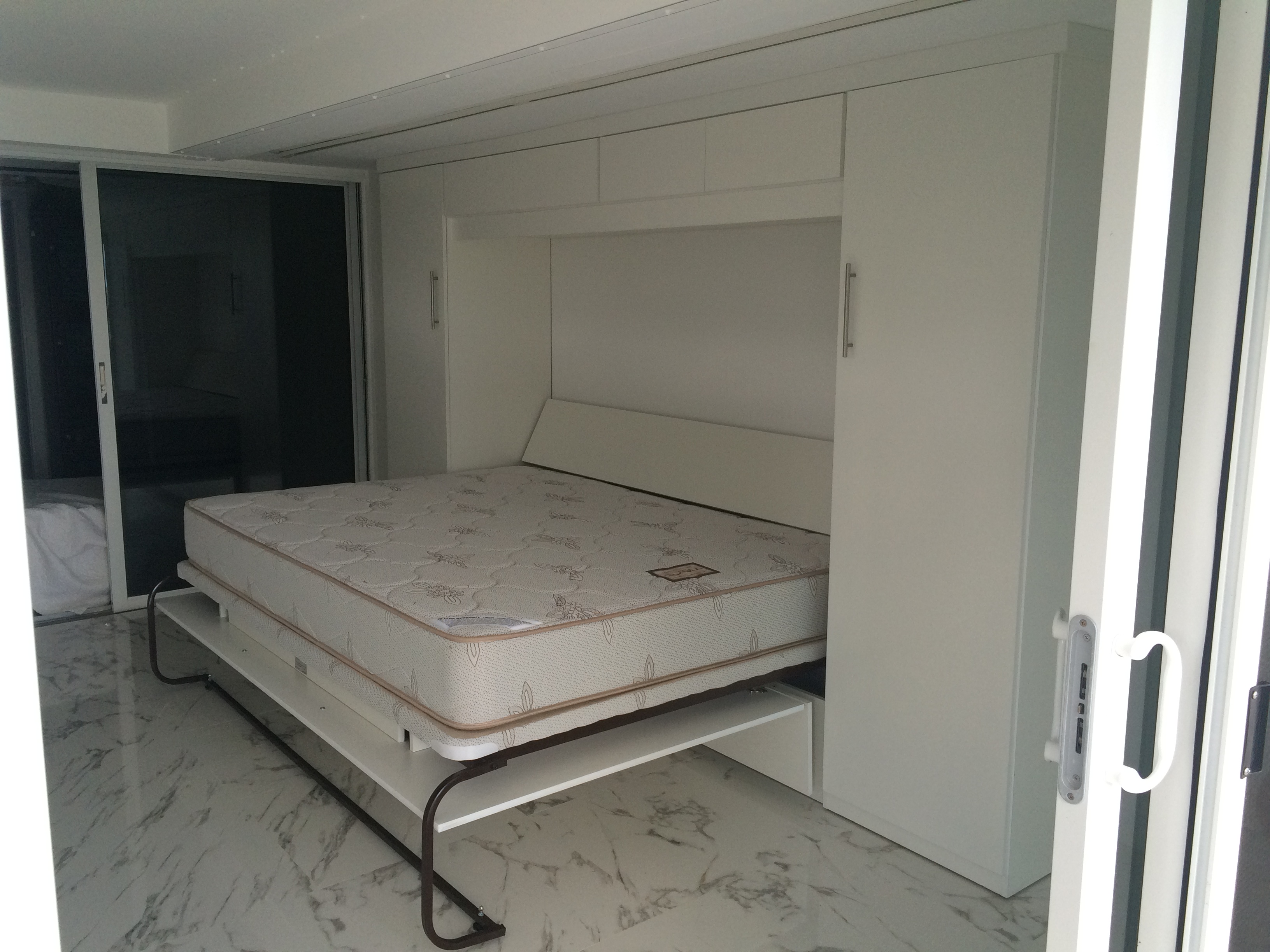 White horizontal Murphy bed open in modern wall cabinet