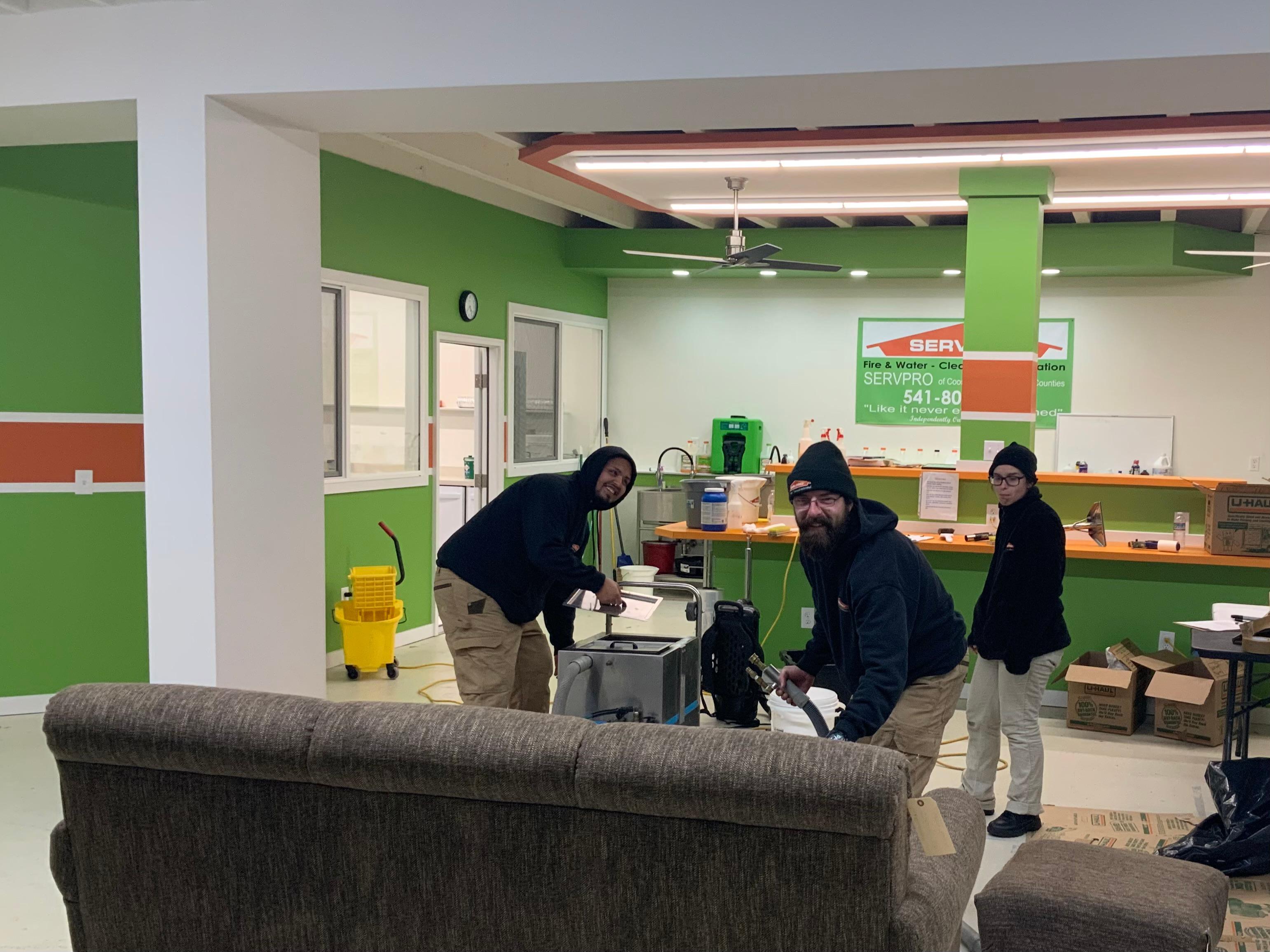 Servpro Cleaning Technicians working hard to remove all smells and stains out of contents from a fire and water loss.