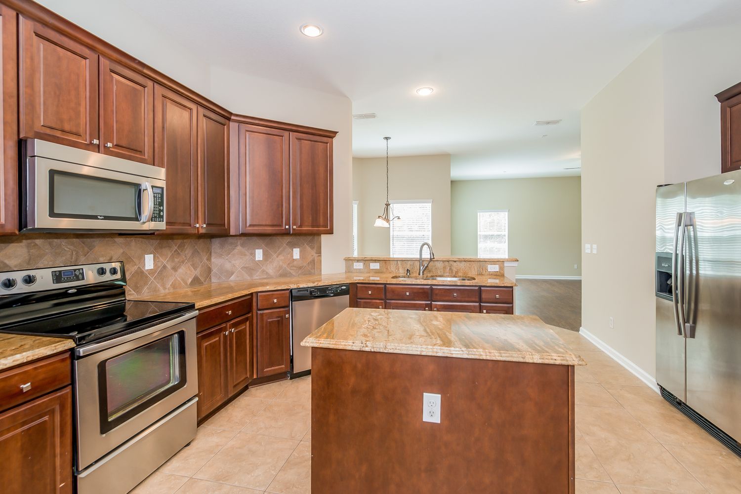 Stunning kitchen with island and stainless steel appliances at Invitation Homes Jacksonville.