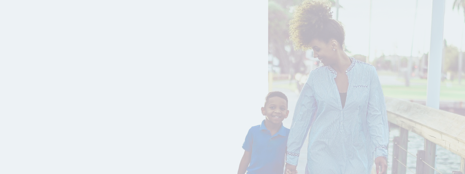 Mom and son walking hand in hand on a pier.